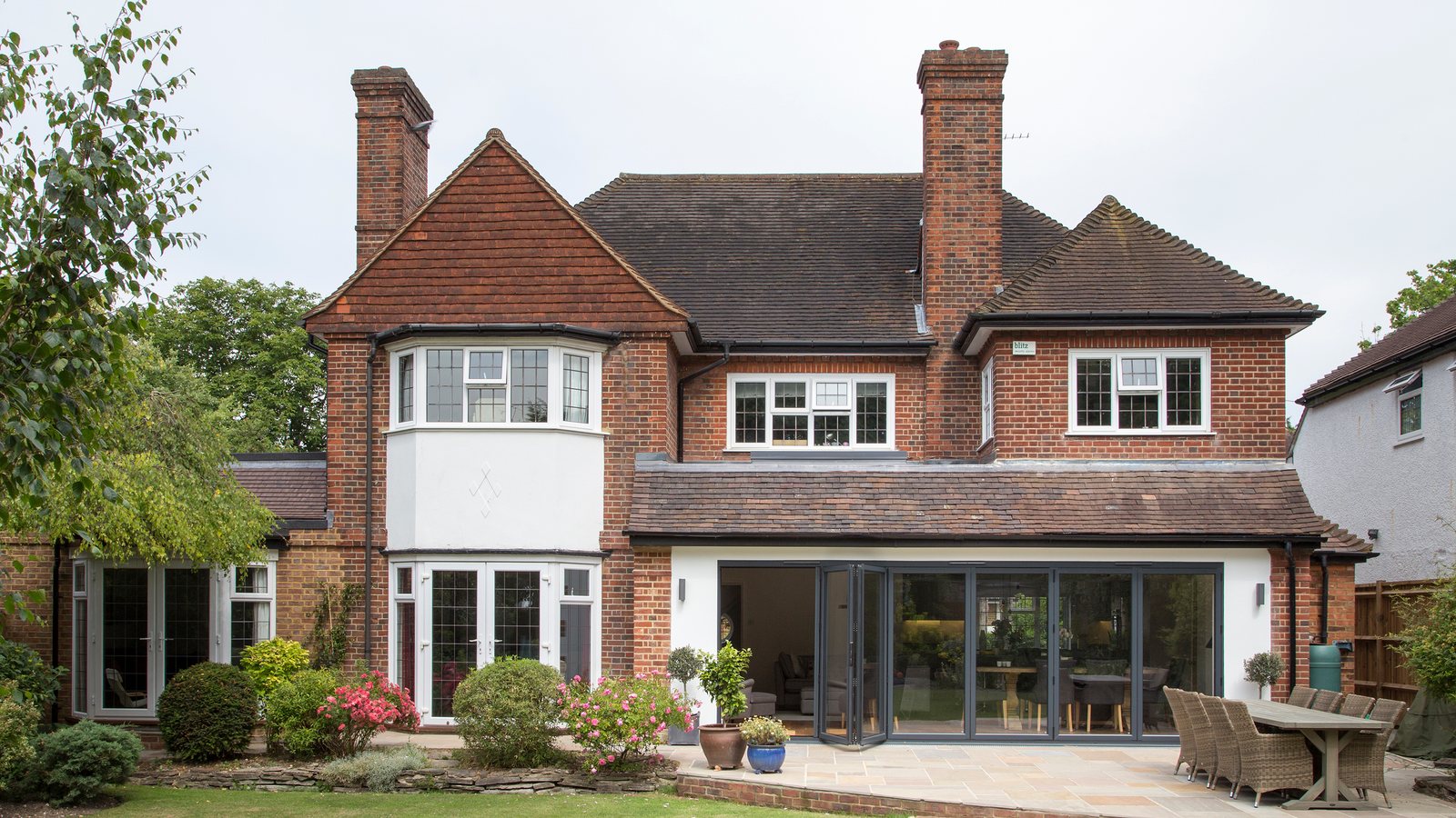 UK detached brick house with a well maintained tiled roof