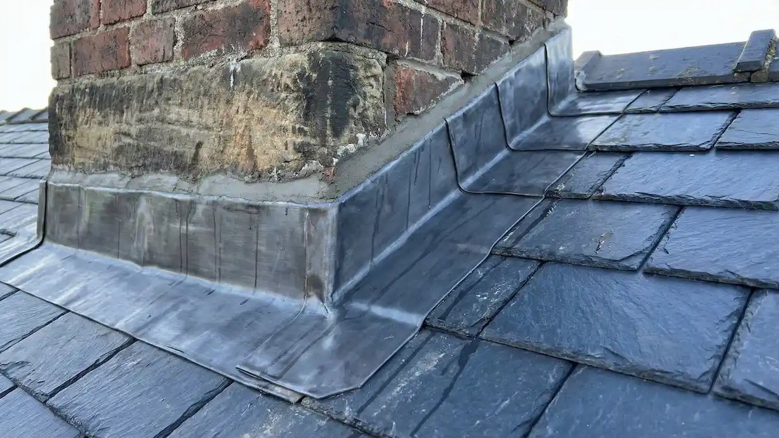 Brick chimney stack with new lead flashing on a UK roof